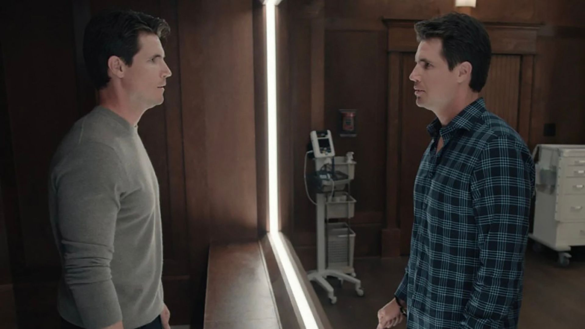 Nathan standing across from his clone as they stare at one another in Upload.