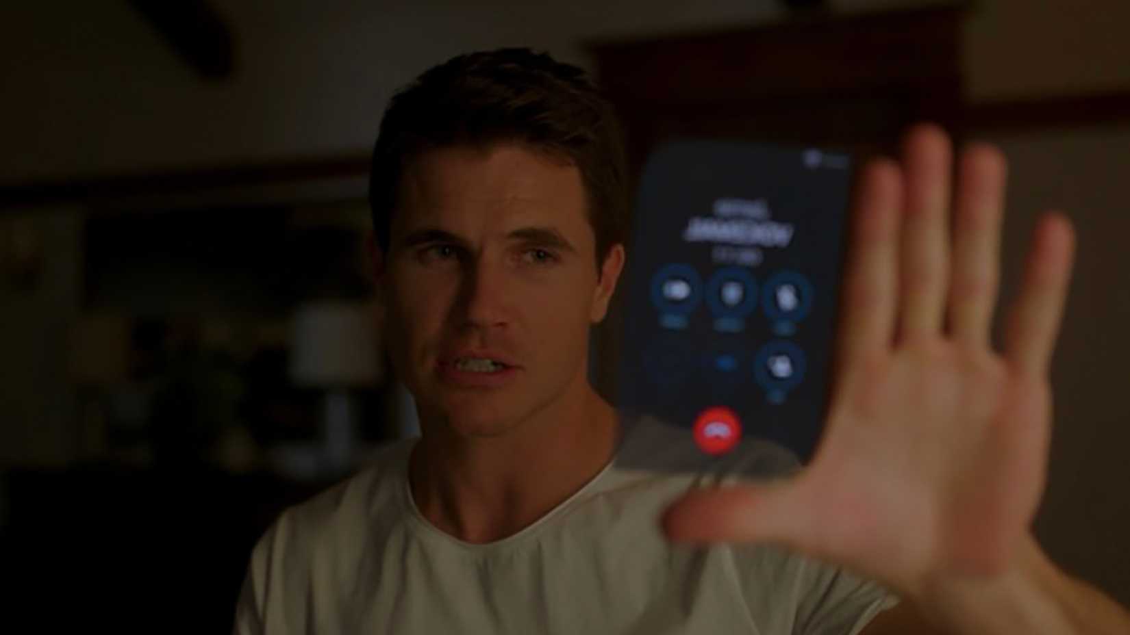 Nathan holding out his hand with a virtual phone appearing in Upload.