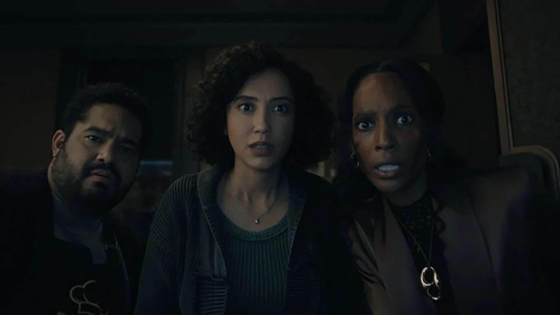 Three people stare at something in the dark in Upload.