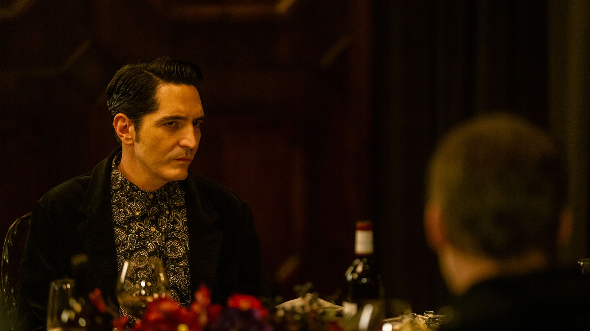 Gareth looking suspiciously at Dexter at Leon's dinner party in Dexter: Resurrection.