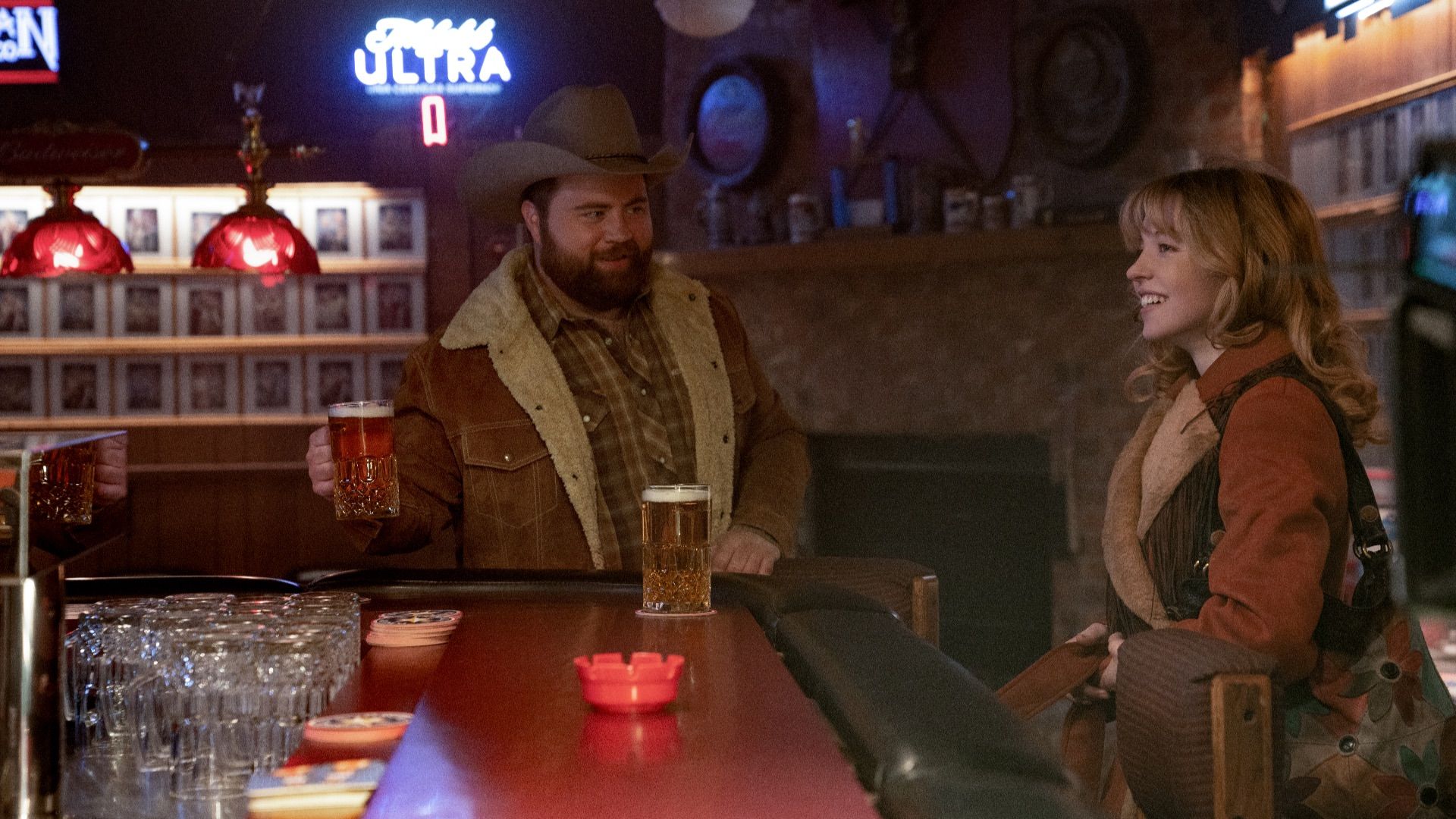 Paul Walter Hauser and Sydney Sweeney at a bar in Americana.