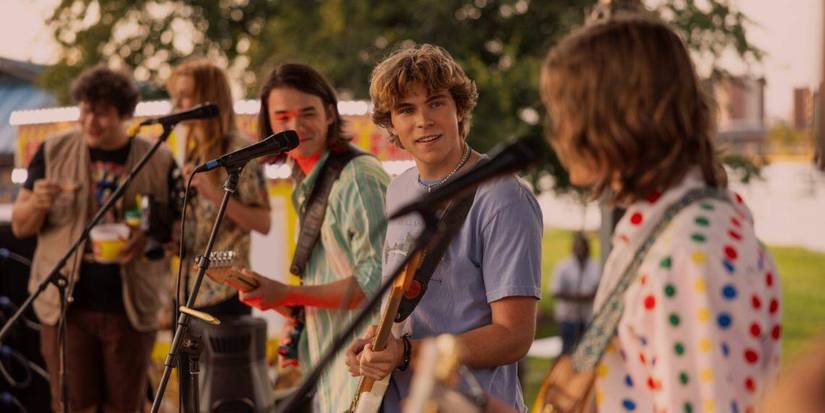 The members/actors in The Runarounds playing a show outside