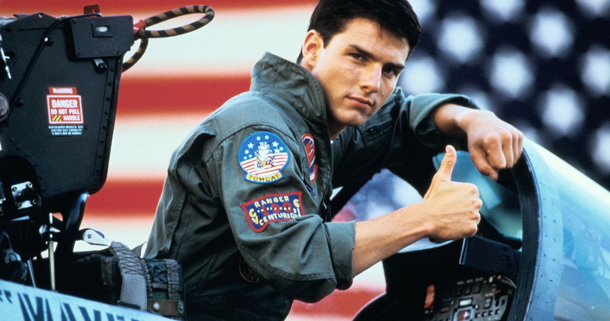 Tom Cruise gives a thumbs up in front of the American flag