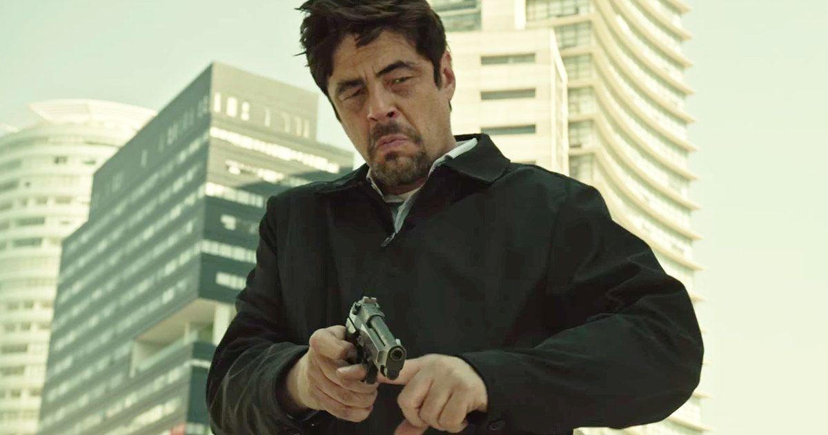 Sicario: Day of Soldado com Benicio Del Toro apontando uma arma para a câmera