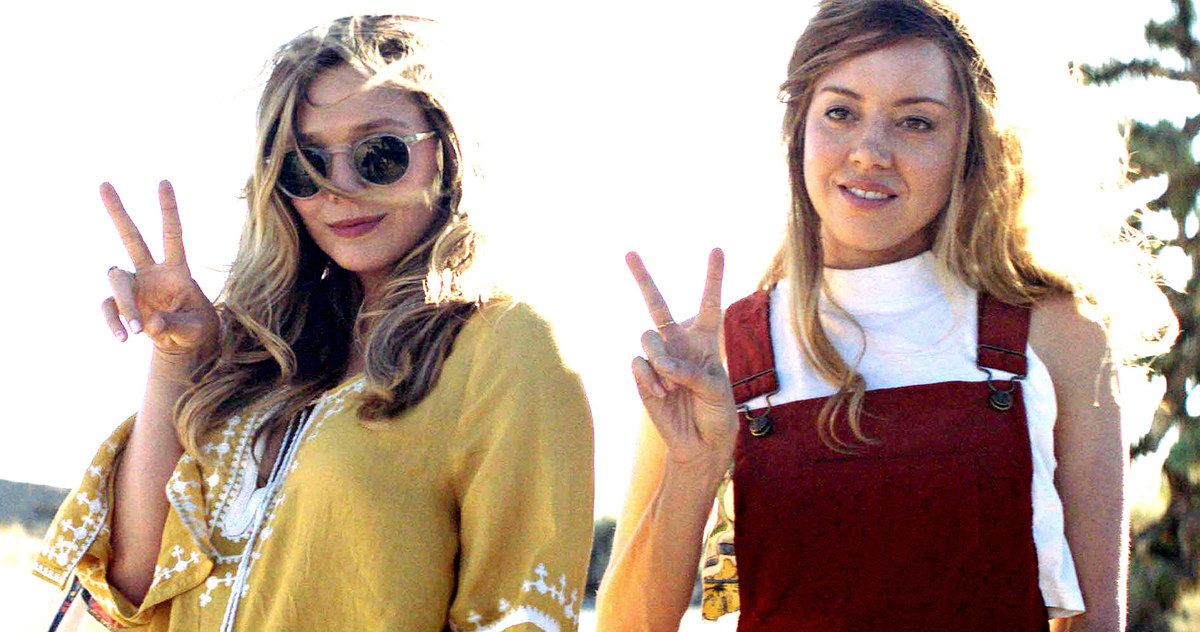 Elizabeth Olsen and Aubrey Plaza make the peace sign