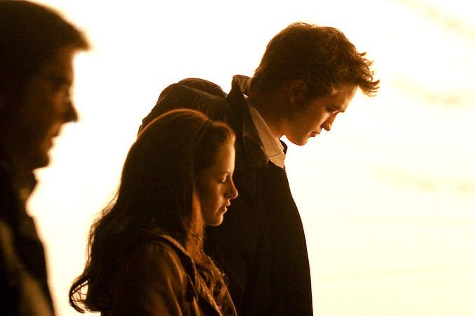 Bathed in light, Robert Pattinson and Kristen Stewart await the start of a scene