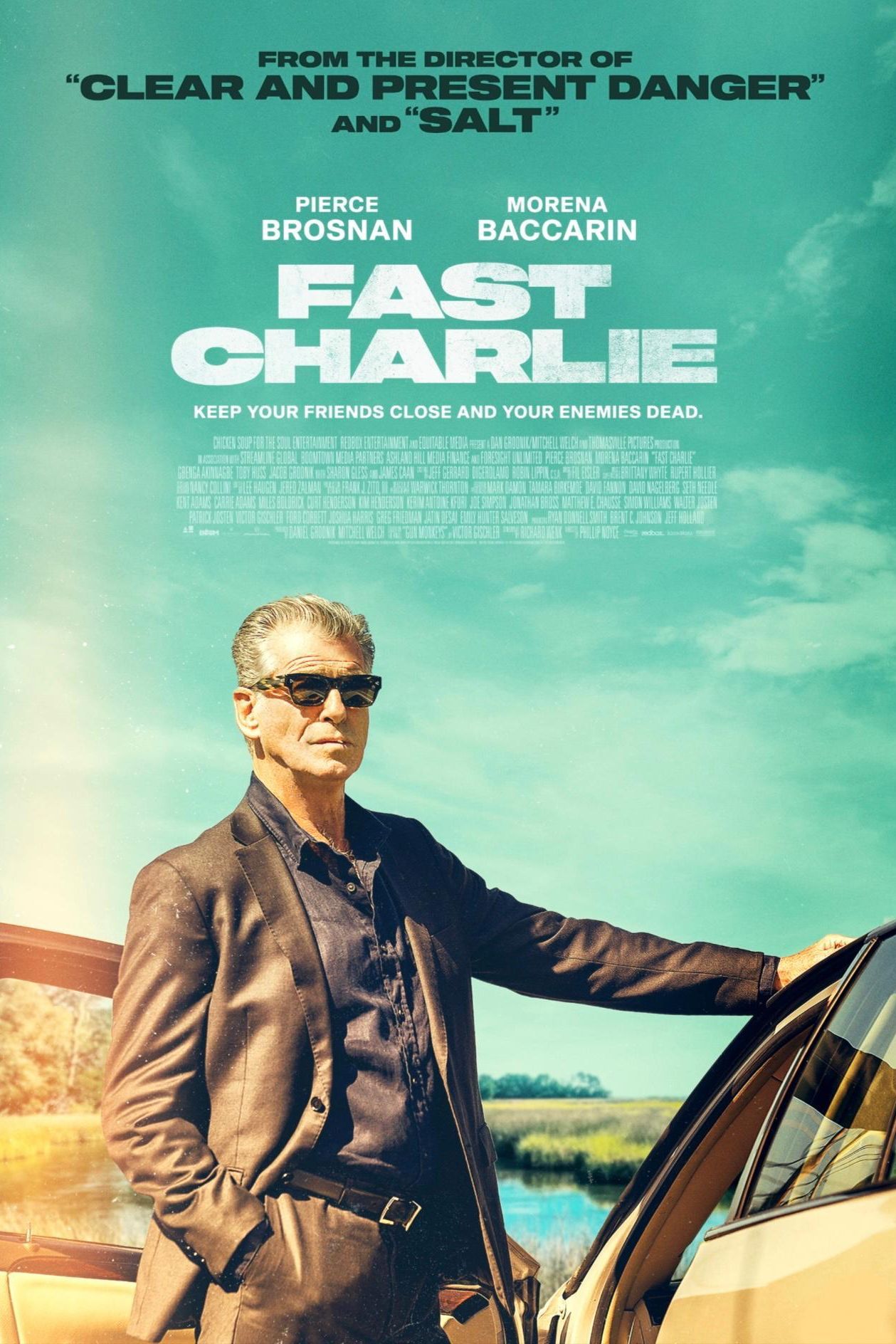 Fast Charlie Movie Poster - man standing against teal sky backdrop, hand on car looking outward